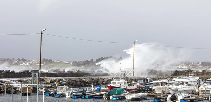 Viser sjøen slå over moloen midt på dagen under stormen i april 2020.