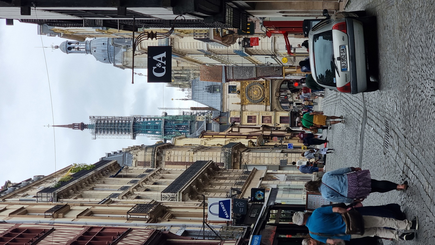 Rue du Gros-Horloge I bakgrunnen ser du det kjente astronomiske klokketårnet fra 1300-tallet som strekker seg over gaten. Spiret som reiser seg bak klokketårnet tilhører den kjente gotiske katedralen Notre-Dame de Rouen.