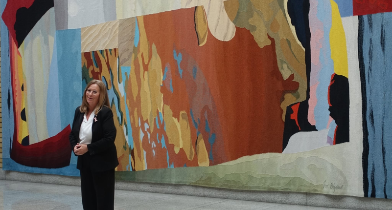 2026.09.29 Tur til Stortinget. Anne Kristine foran den stor vevnaden Landskap av Sissel Blystad - i Vandrehallen. Foto Grunde Vale.