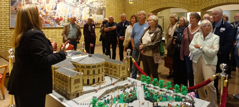2026.09.29 Tur til Stortinget. Anne Kristine Linnestad foran legomodellen av Stortinget i Trappehallen. Foto Grunde Vale.