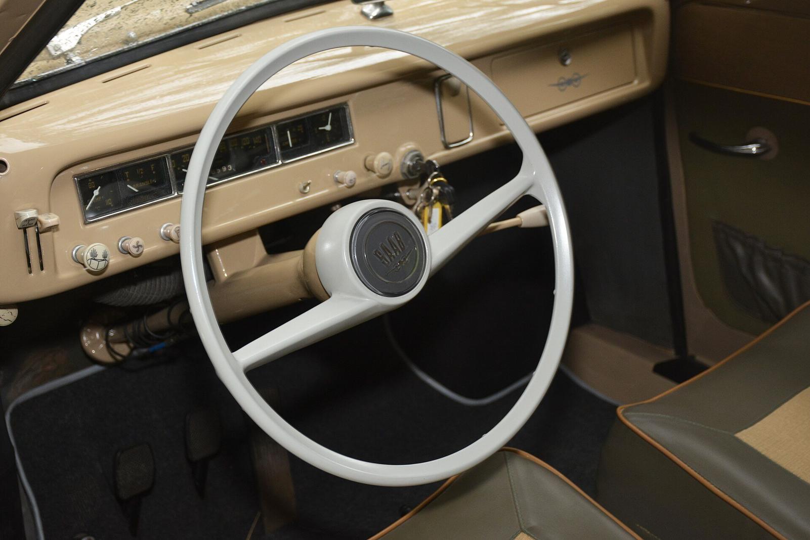 Førerplassen i en Saab 93 med lyst ratt og beige dashbord