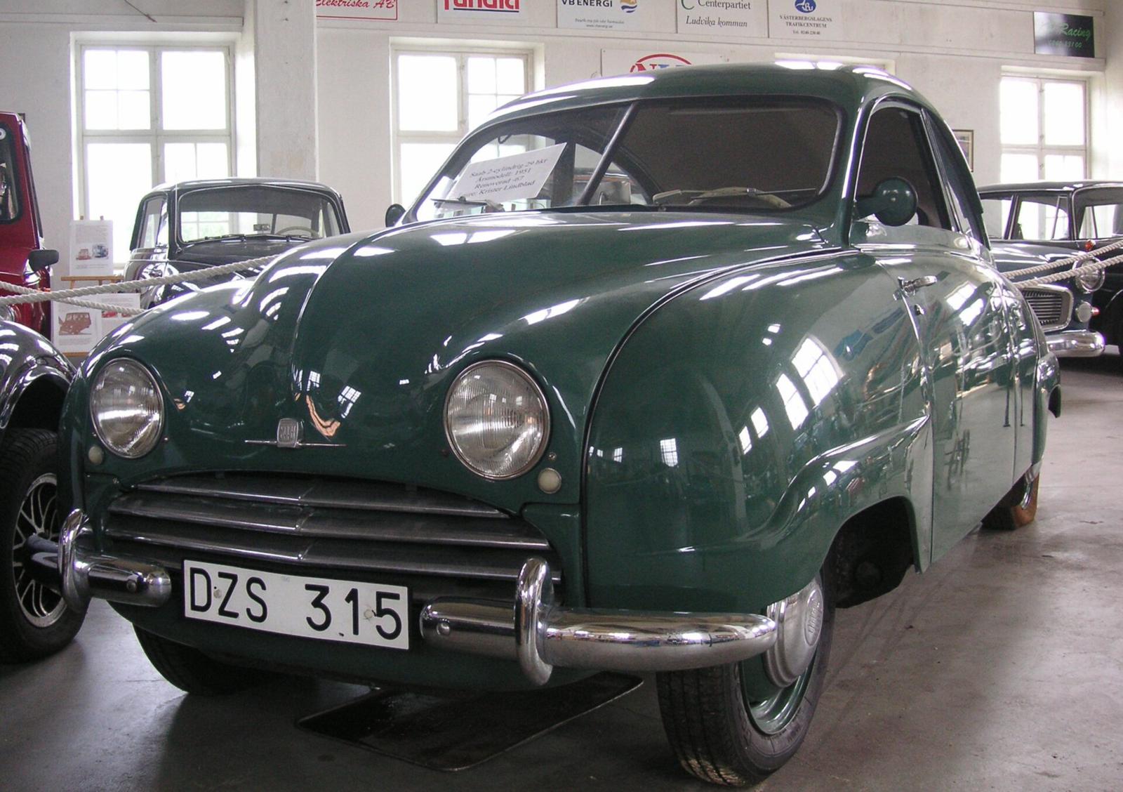 Grønn Saab 92 sett skrått forfra i en museumshall