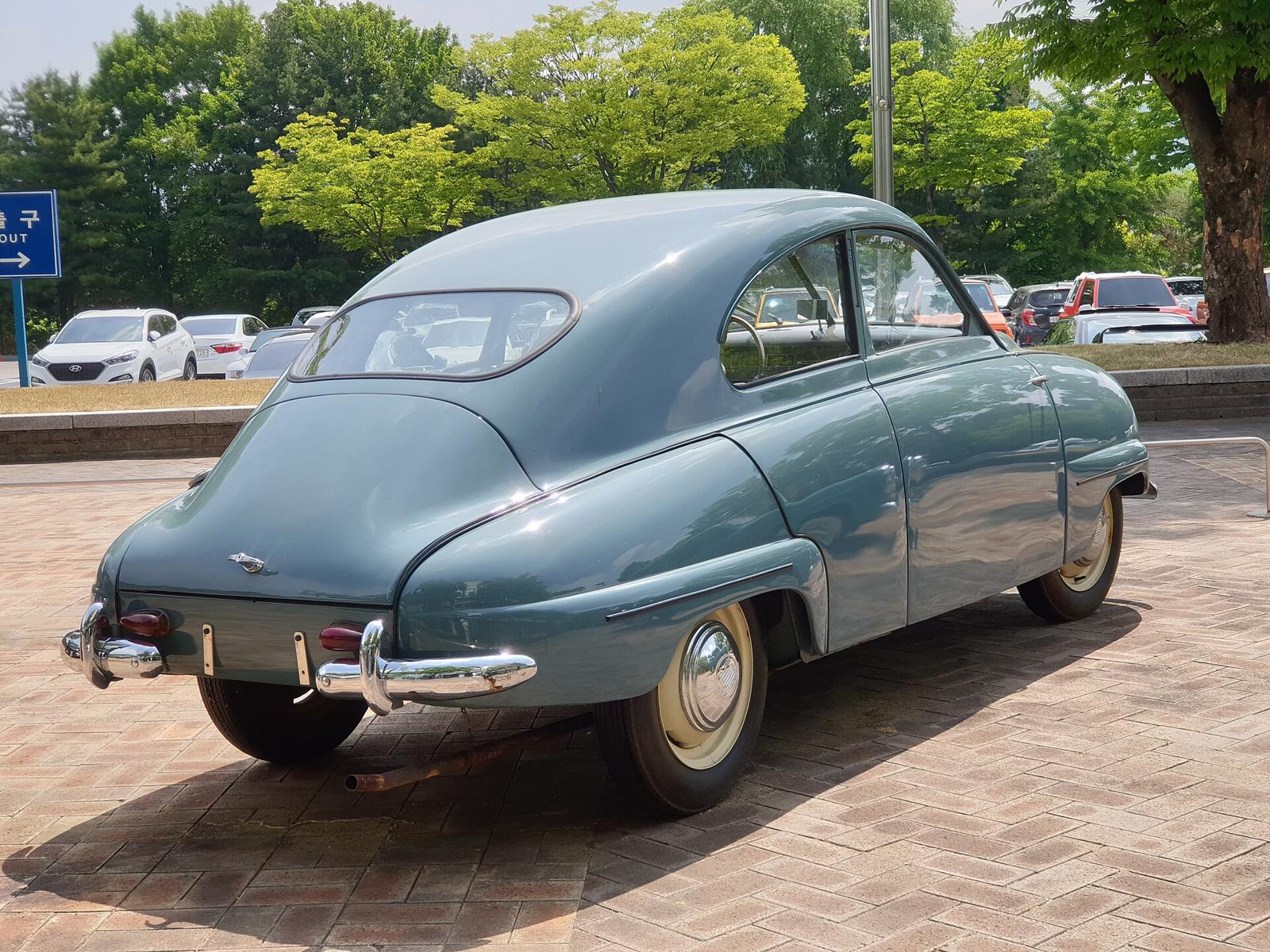 Lyseblå Saab 92B sett skrått bakfra på en parkeringsplass