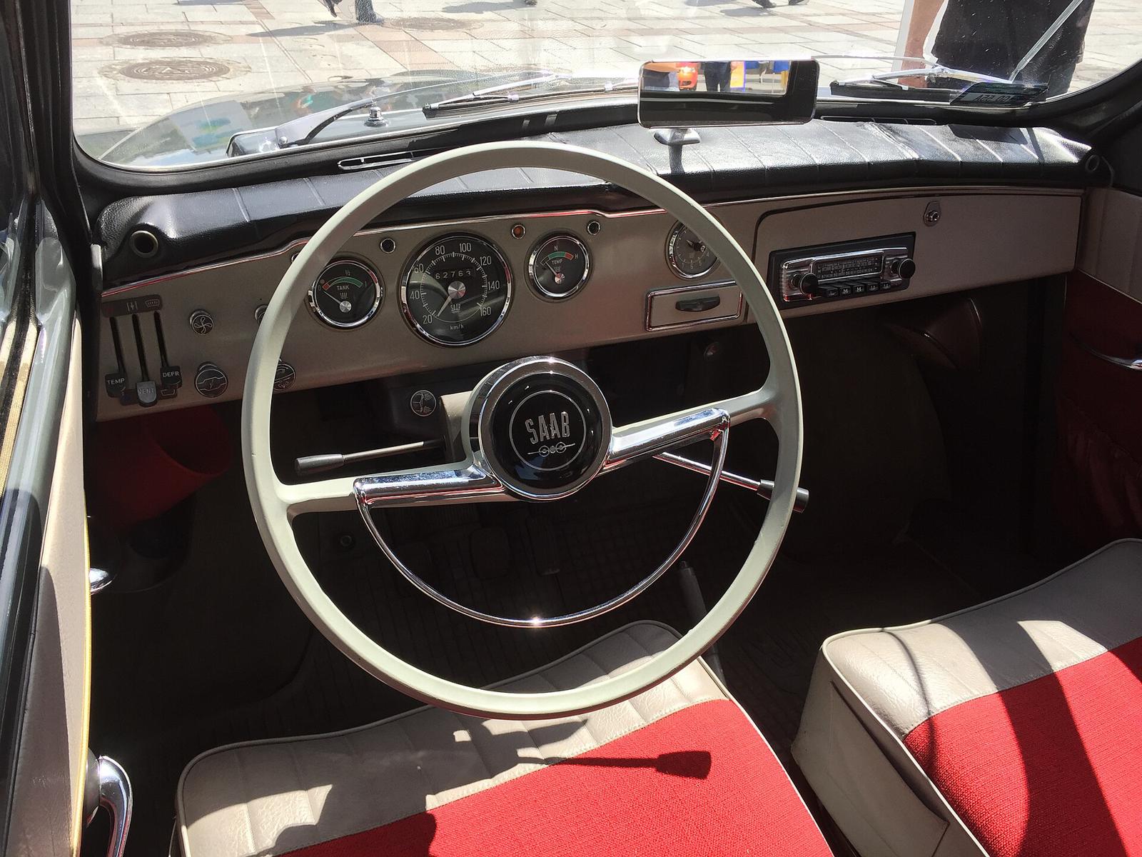Førerplassen i en Saab 95 med stort, lyst ratt og runde instrumenter