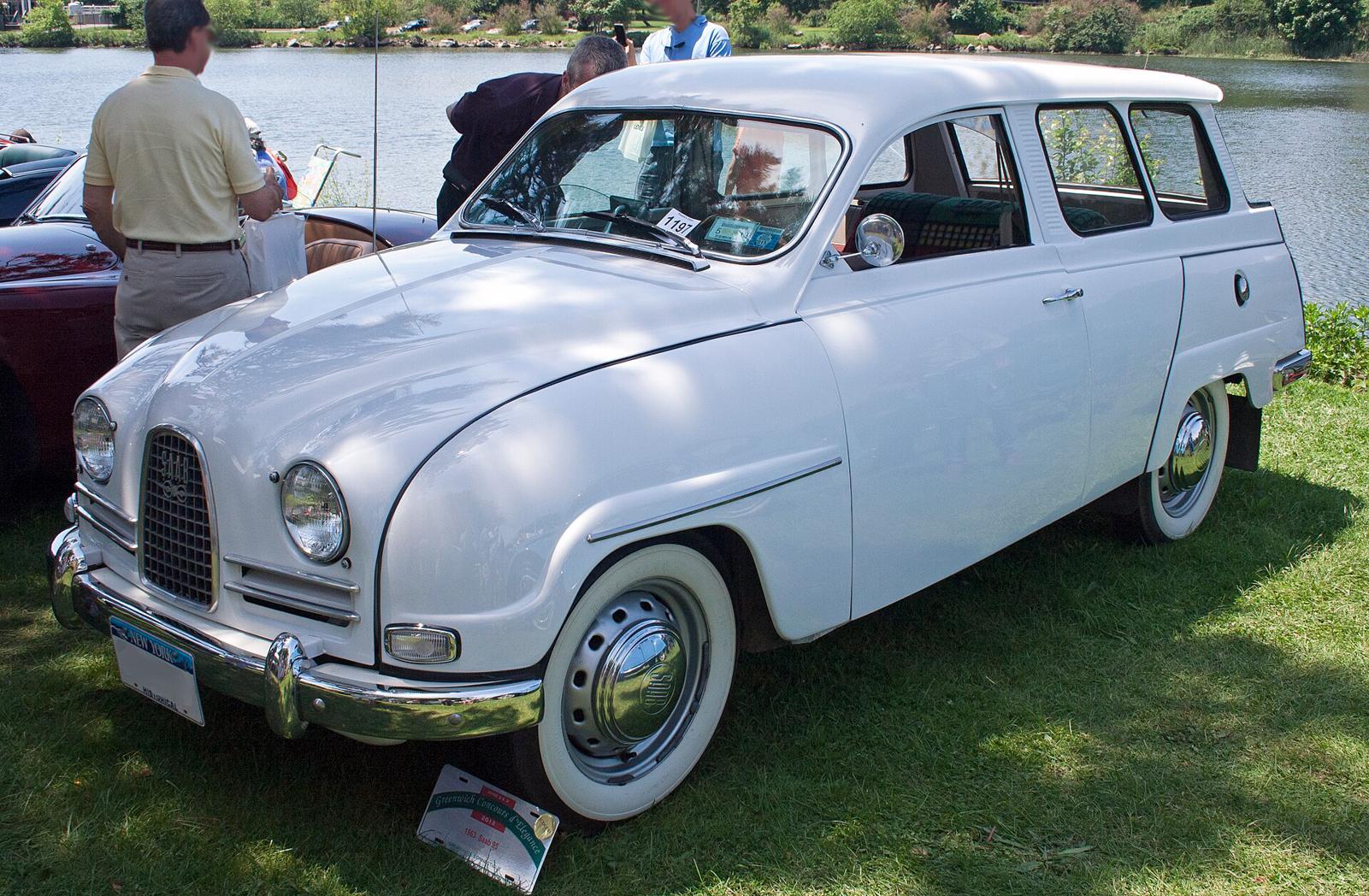 Hvit Saab 95 med kort, rund front, sett skrått forfra på en gressplen