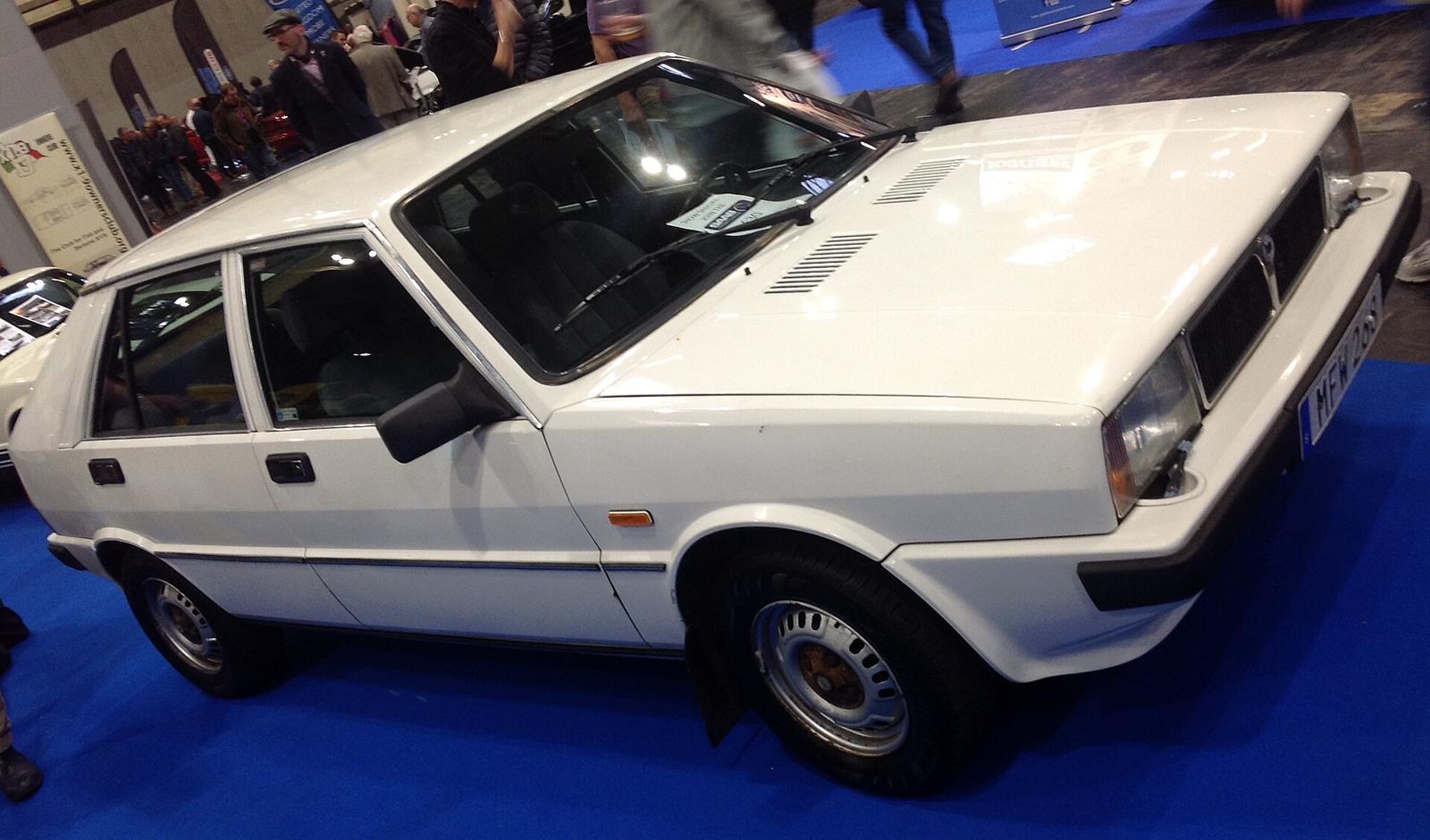 Hvit Saab-Lancia 600 GLS sett skrått forfra fra høyre, med lufteriller på panseret