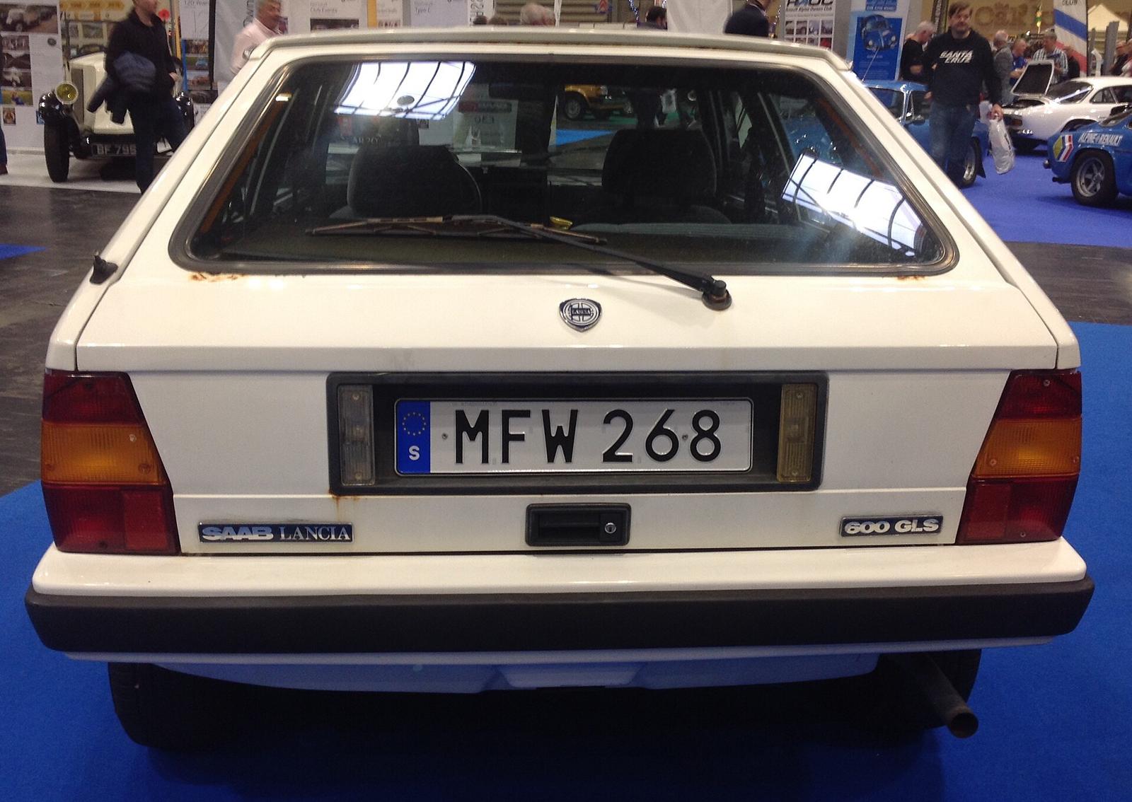 Hvit Saab-Lancia 600 GLS rett bakfra med rustflekker langs kanten av bakruten