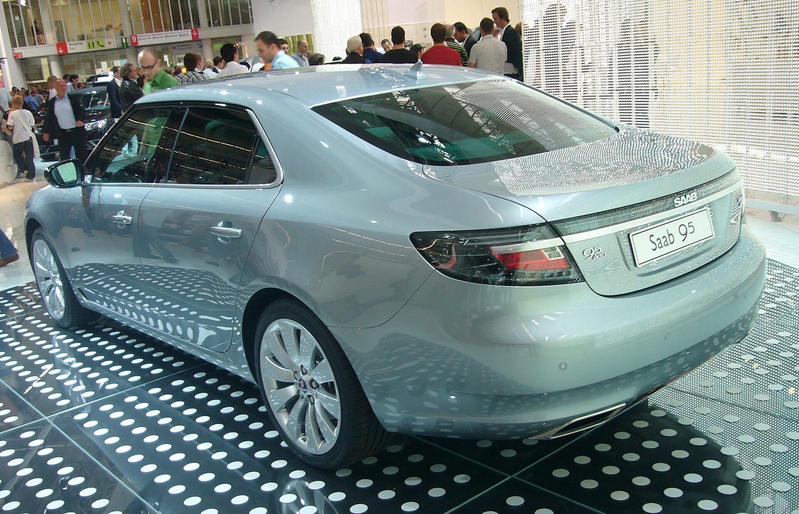 Sølvgrå Saab 9-5 Aero sett skrått bakfra på en utstillingsstand