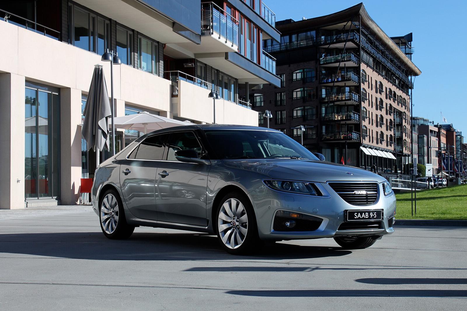 Grå Saab 9-5 parkert foran moderne bygninger ved sjøen