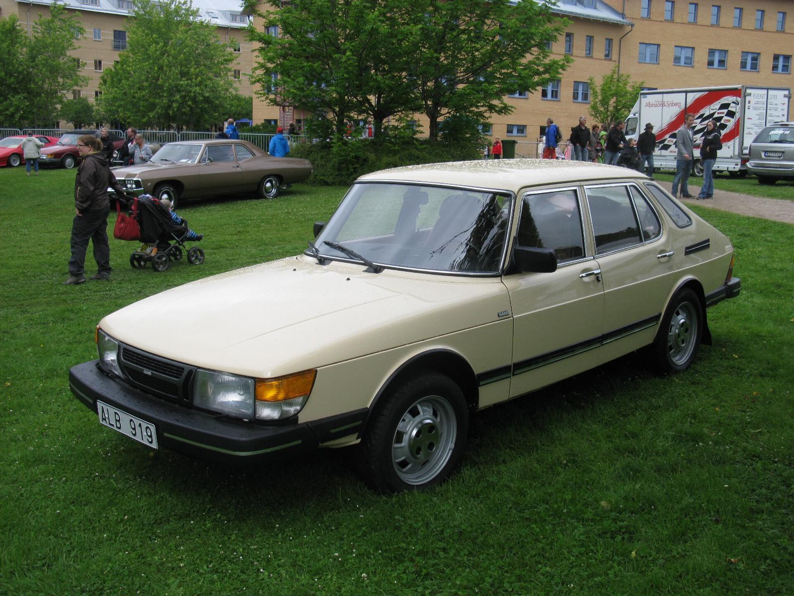 Beige Saab 900 GLi femdørs med tidlig, rett front på en bilutstilling