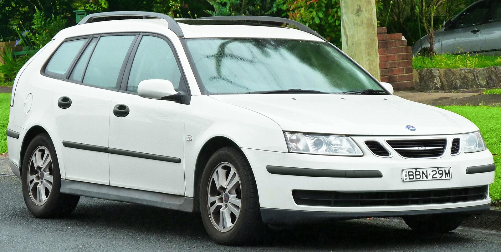 Hvit Saab 9-3 SportCombi stasjonsvogn med takrails, sett skrått forfra på en gate