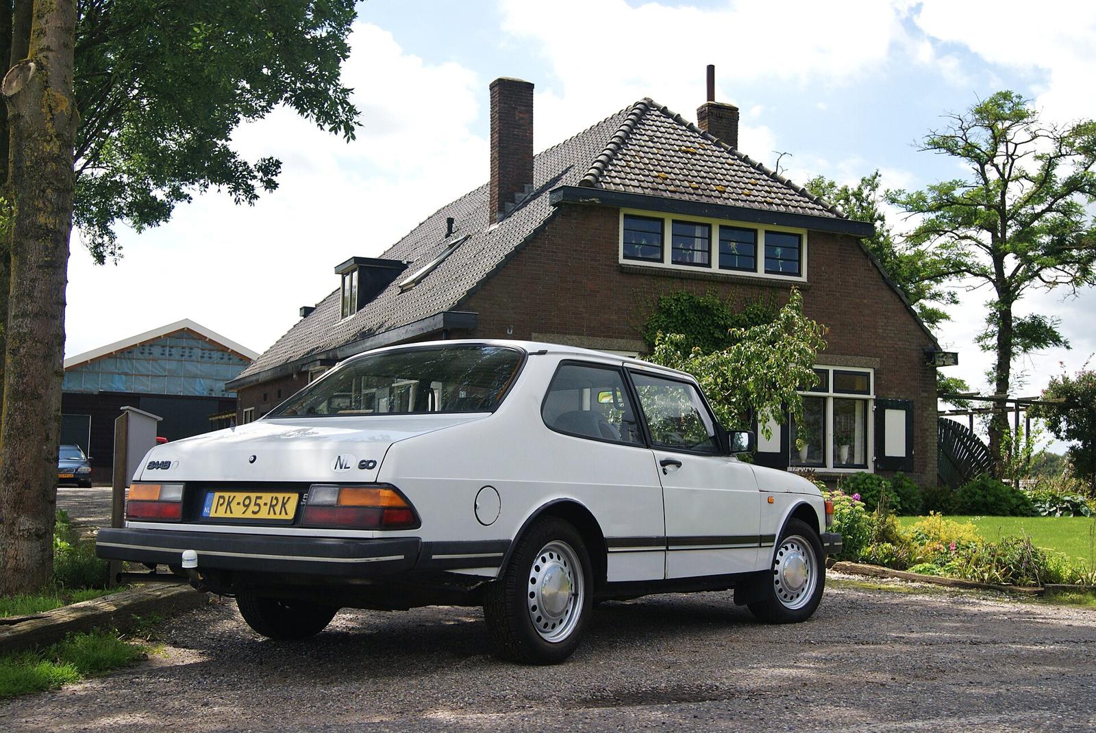 Hvit Saab 90 sett skrått bakfra foran et murhus