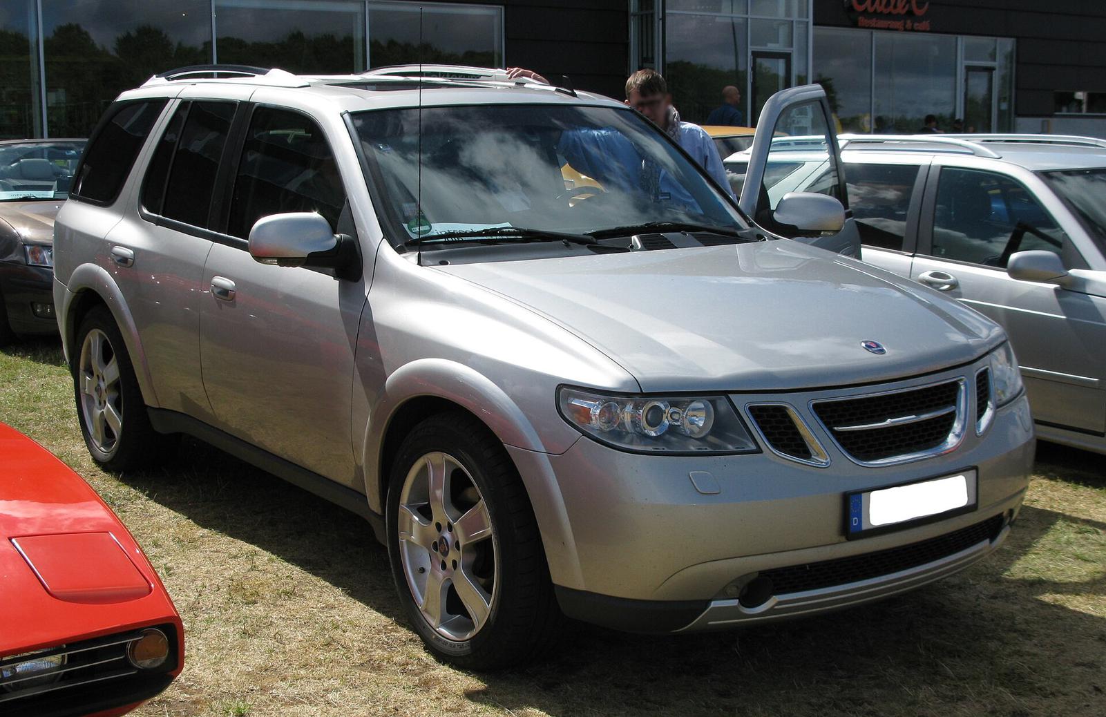 Sølvfarget Saab 9-7X med tysk skilt på en gressplen blant andre Saab-biler