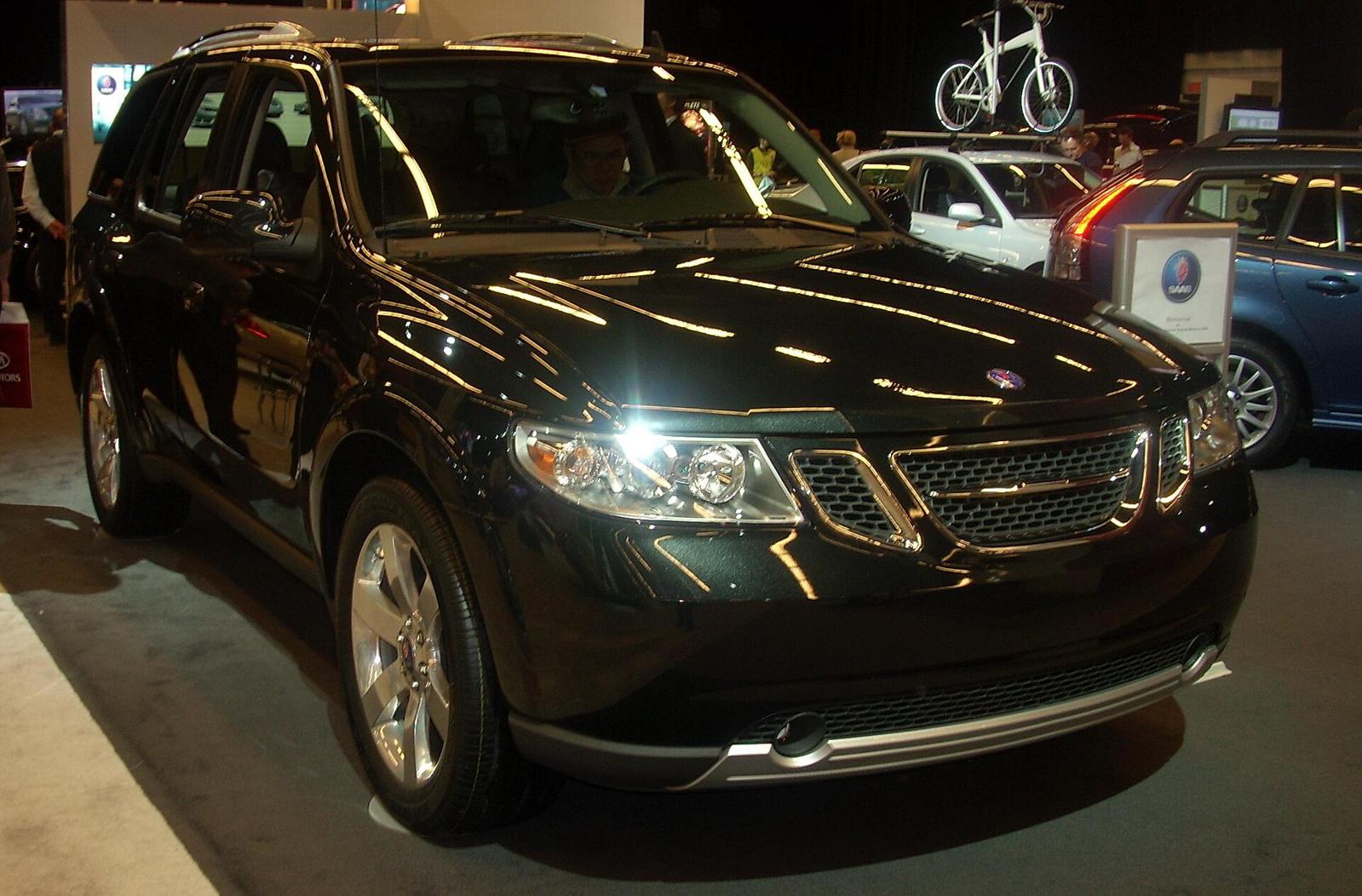 Svart Saab 9-7X sett skrått forfra på en bilutstilling, med Saab-skilt i bakgrunnen
