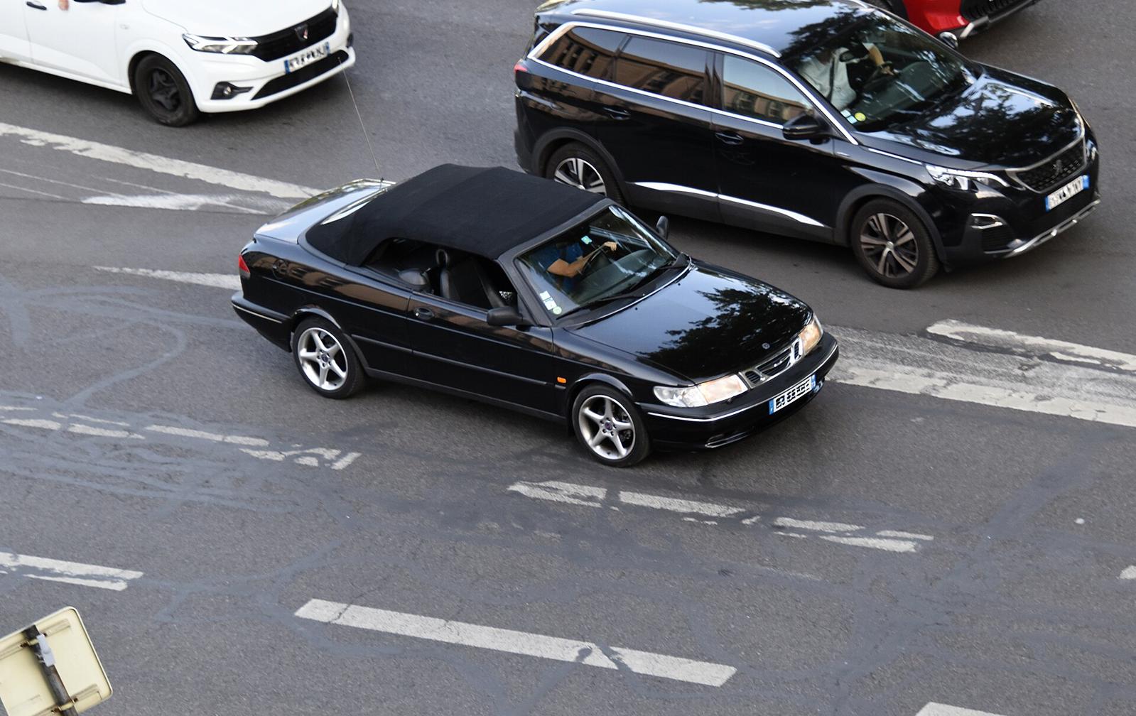 Svart Saab 900 cabriolet med kalesjen oppe, sett ovenfra i en gate