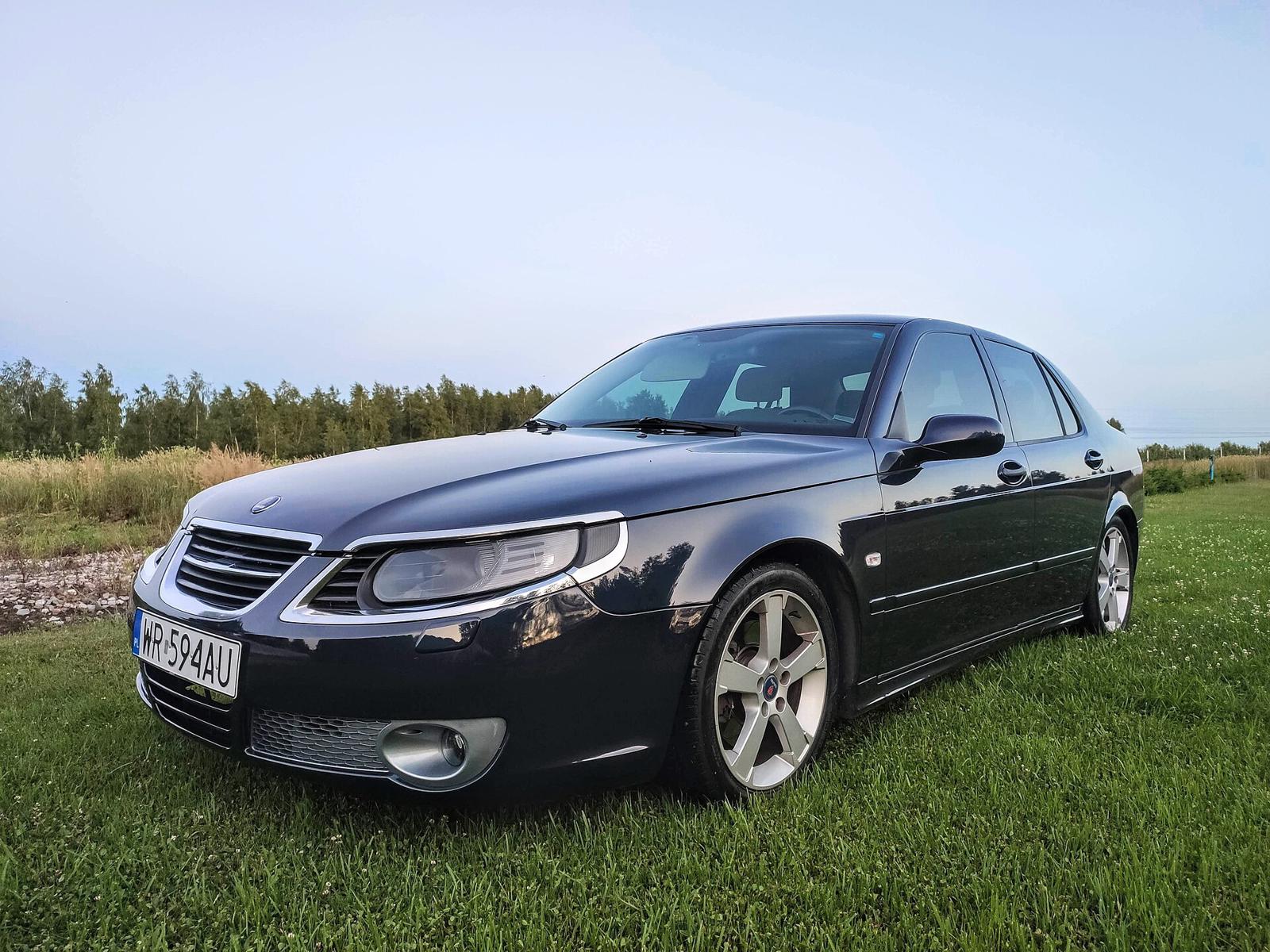 Mørk Saab 9-5 Aero sedan på en gressplen, med kromrammer rundt frontlyktene