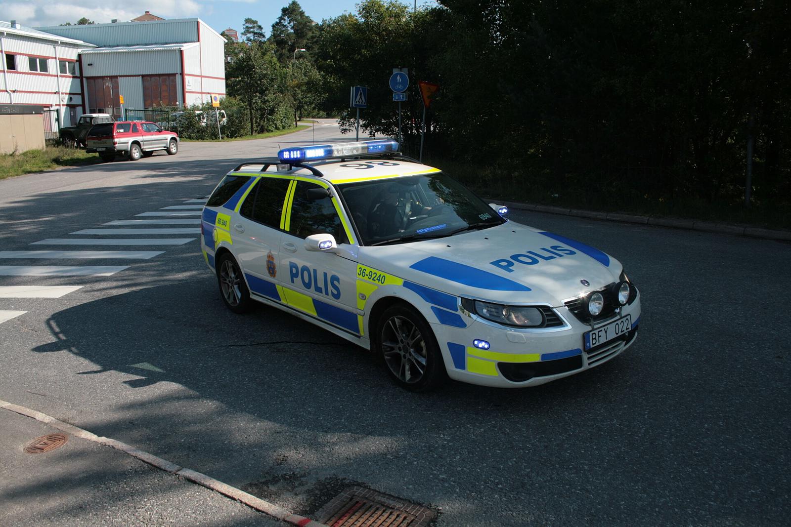Svensk politibil, Saab 9-5 SportCombi i politidekor med blålys, svinger ut i et kryss