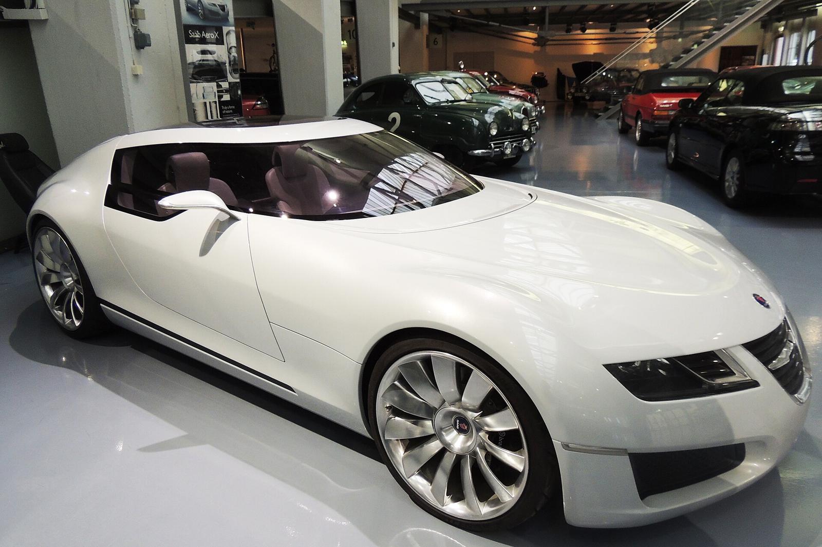 Hvit Saab Aero X sett skrått forfra i en museumshall med andre Saab-biler i bakgrunnen
